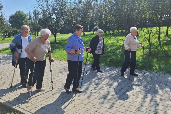 Rozgrzewka na rowerkach i machanie rączkami, a potem kijki w ruch i wspólny spacer